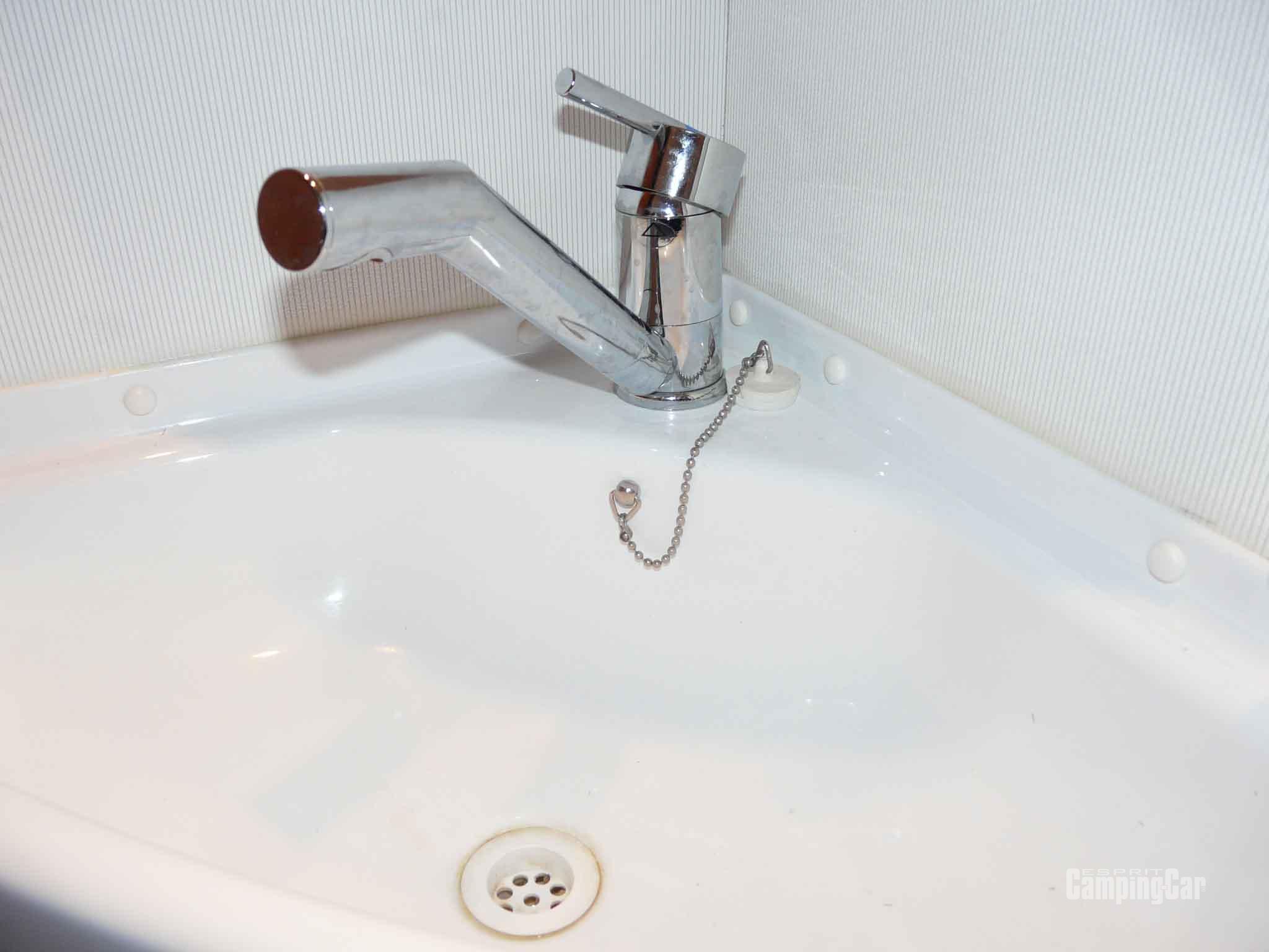 Robinet mitigeur ouvert sur un lavabo de camping-car, sans écoulement d'eau