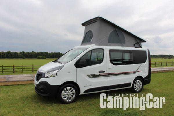 van aménagé Adria avec toit relevable ouvert, stationné dans un pré