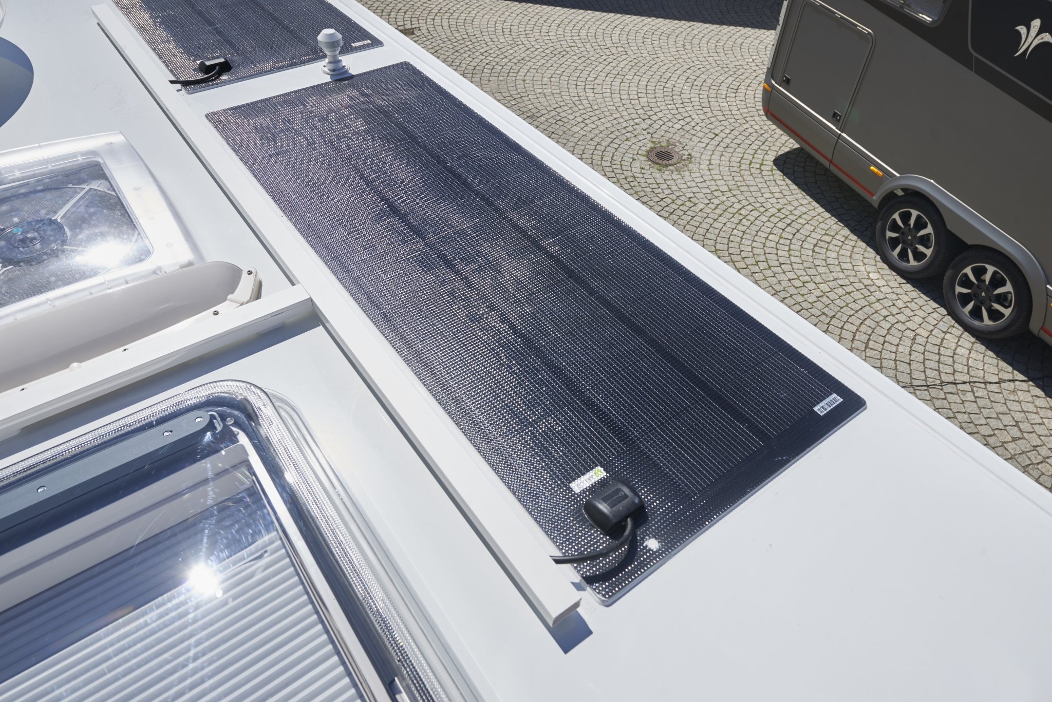 Panneau solaire fixé sur le toit d'un camping-car, passage de câble vers l'intérieur
