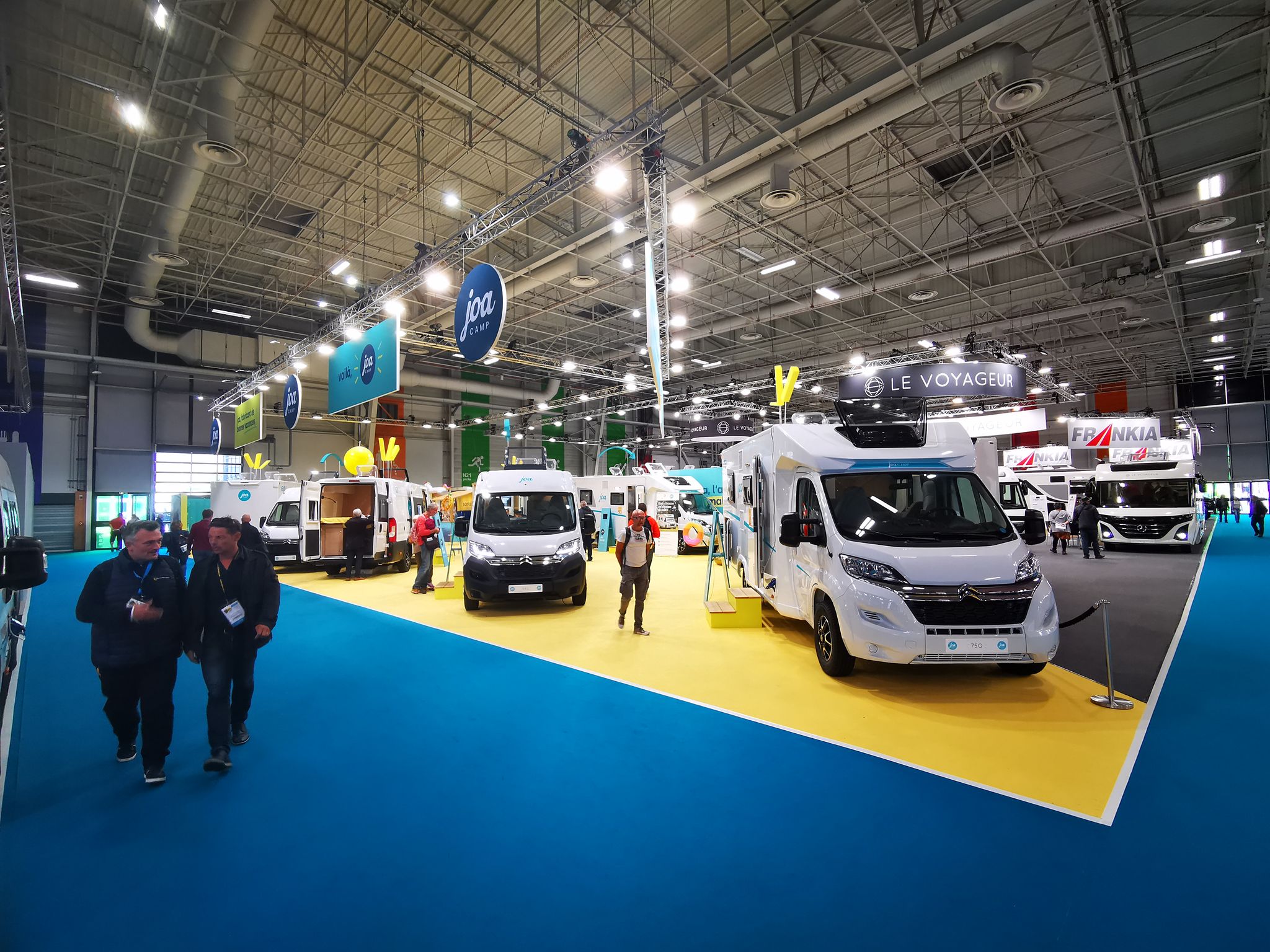 Veille camping-car : allée d'un salon français du véhicule de loisirs avec stands de constructeurs