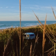 Aire camping-car bord de mer parmi les buissons face à l'océan