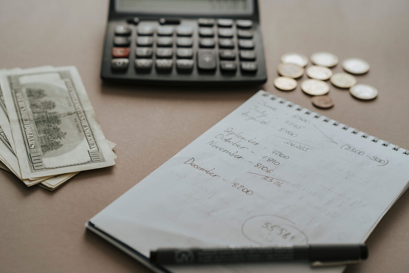 Calcul du budget vacances camping-car avec calculatrice et espèces sur une table
