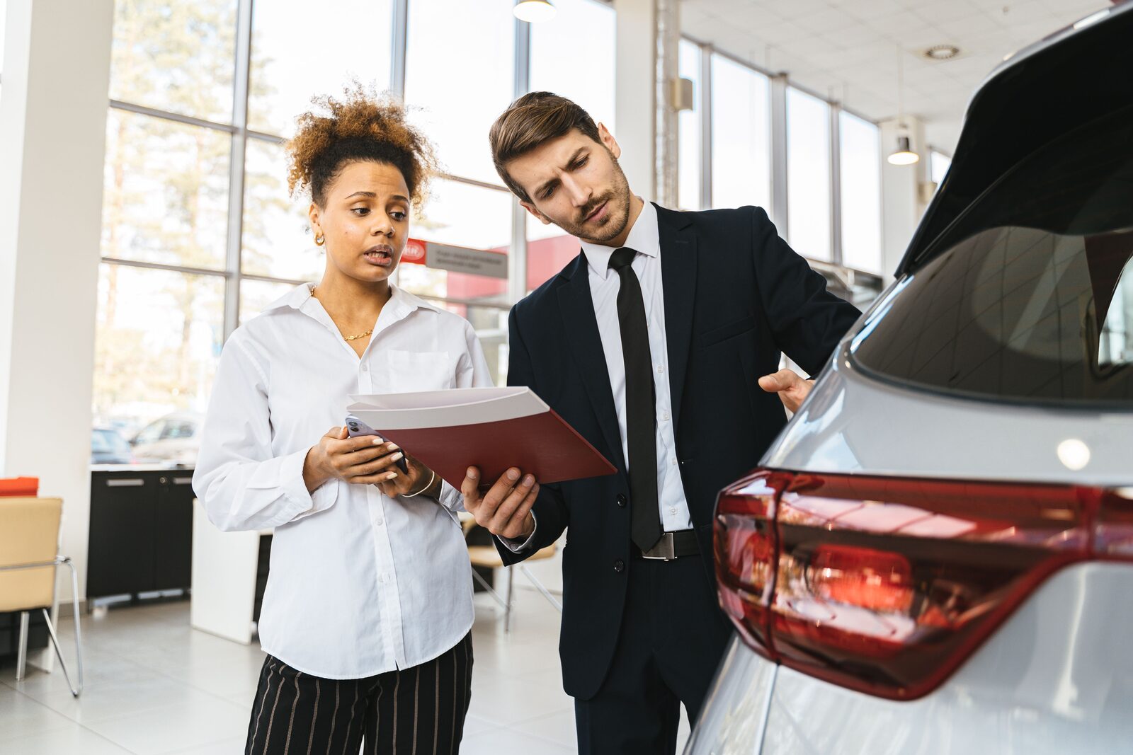 Conseiller en concession expliquant les modalités du leasing camping-car à un client