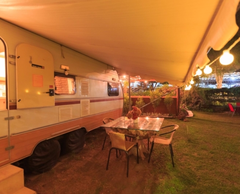 Auvent camping-car deploye et eclaire lors d une soiree en camping