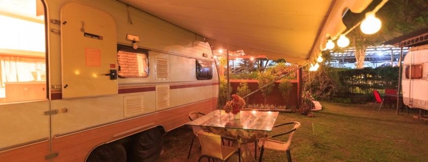 Auvent camping-car deploye et eclaire lors d une soiree en camping