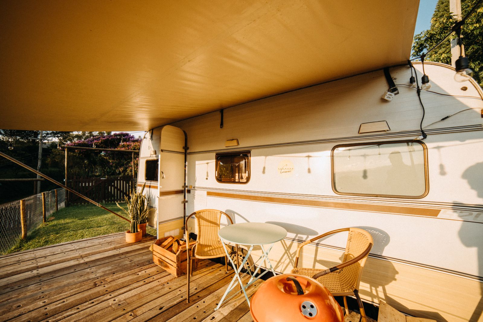 Terrasse aménagée sous un auvent avec chaises et table de camping