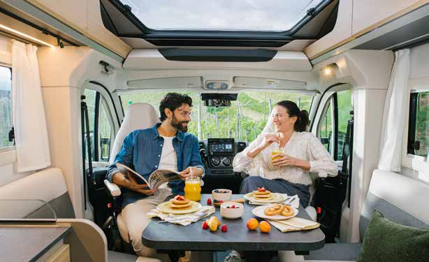 Dînette de l'Adria Compact 2027 sous la fenêtre panoramique