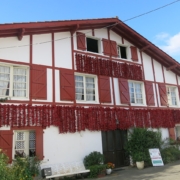 Camping-car au Pays basque : façade d'une maison d'Espelette couverte de cordes de piments qui sèchent