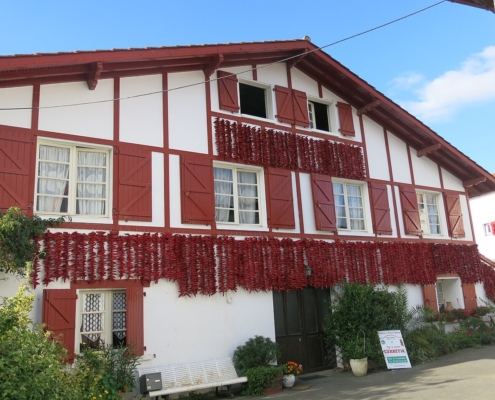 Camping-car au Pays basque : façade d'une maison d'Espelette couverte de cordes de piments qui sèchent