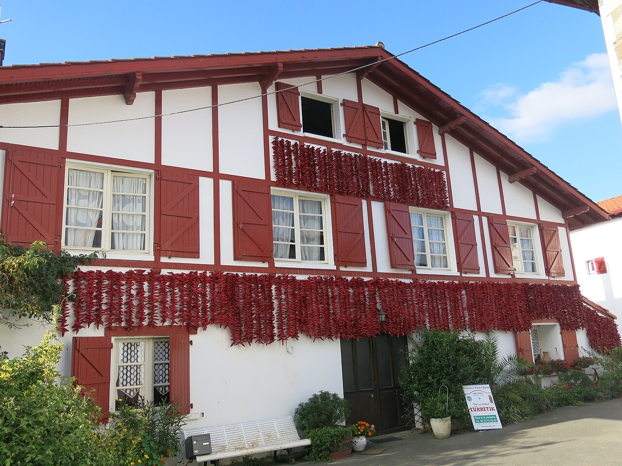 Camping-car au Pays basque : façade d'une maison d'Espelette couverte de cordes de piments qui sèchent